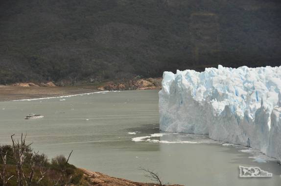Um grande barco com turistas fica pequeno perto das paredes de gelo do glaciar Perito Moreno, no parque Nacional Los Glaciares, região de El Calafate, no sul da Argentina
